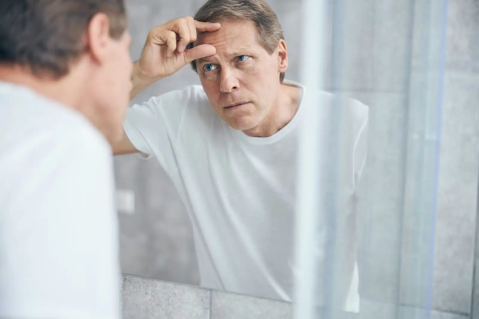A man looking at the mirror.