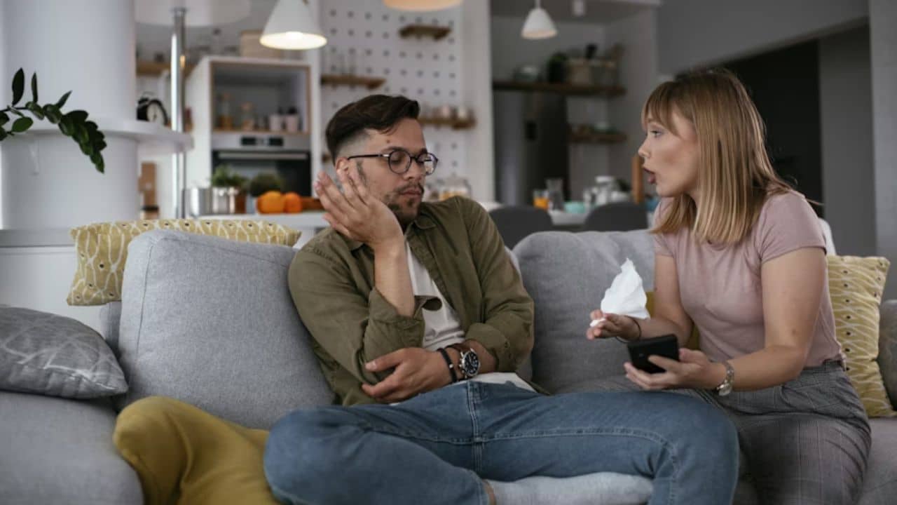 Woman yelling at her partner arguing on the couch.