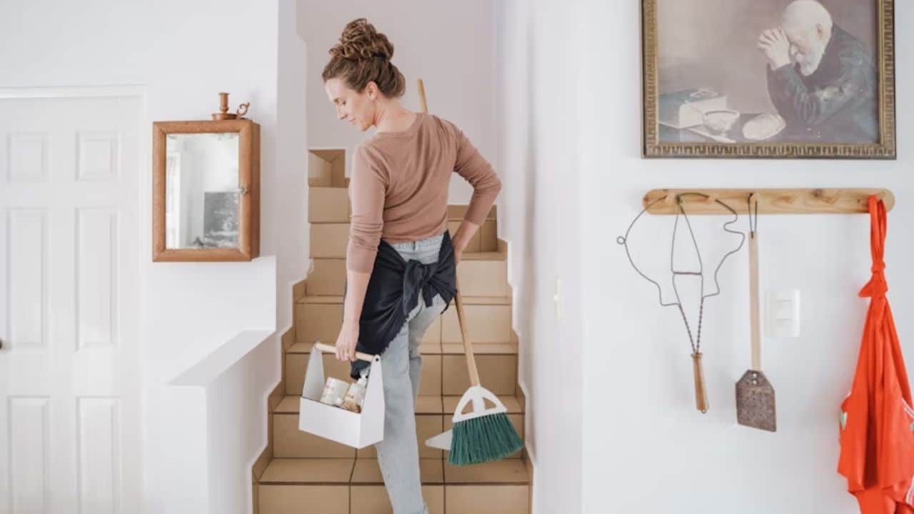 Woman keeping herself busy cleaning the whole house to avoid emotional drainage.