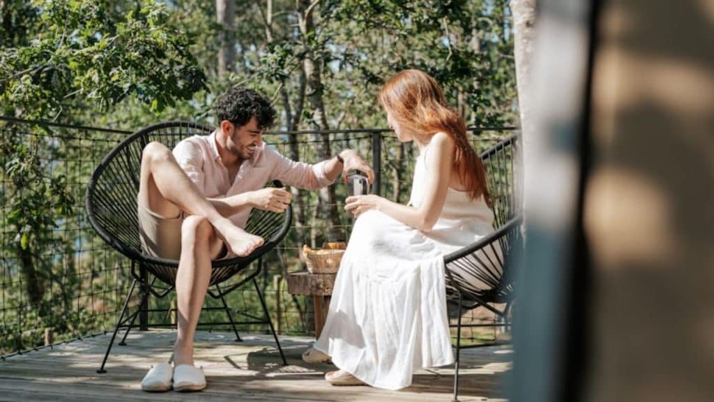 Man and a woman sitting on a chair enjoying breakfast.