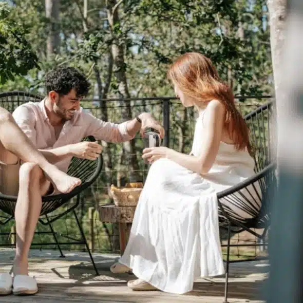 Man and a woman sitting on a chair enjoying breakfast.