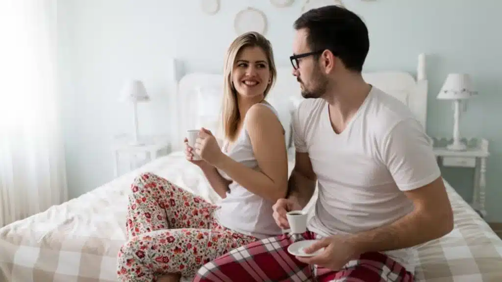 Couple having coffee in the bedroom.