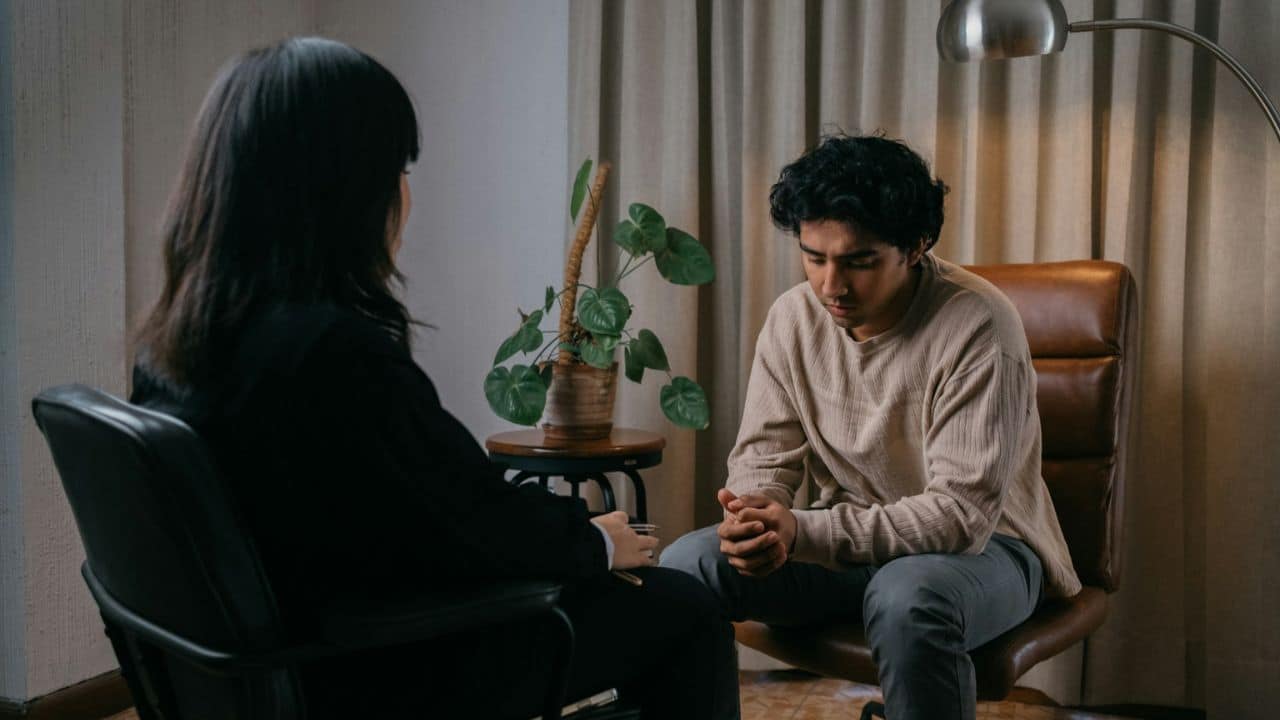 A male and a female sitting in chairs across from each other.