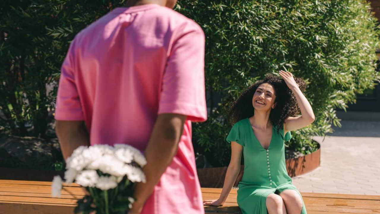 Man surprising a woman with a bouquet of flowers.