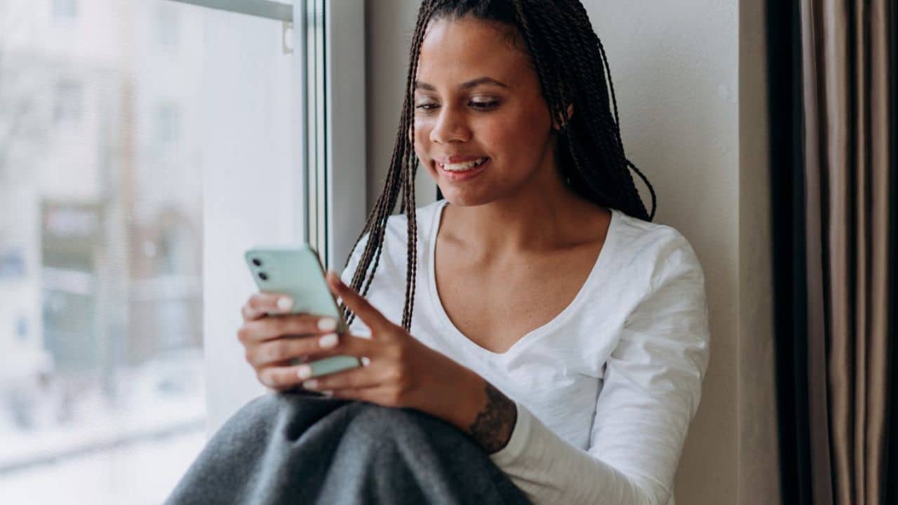 Woman with calm expression texting back thoughtfully.