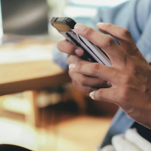 A person using a smartphone at a desk.