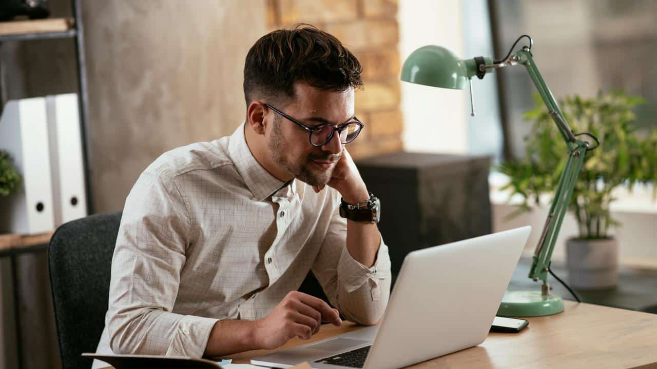 A man working on a laptop at his desk.