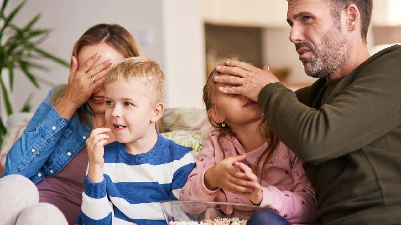 A family reacting while watching TV.