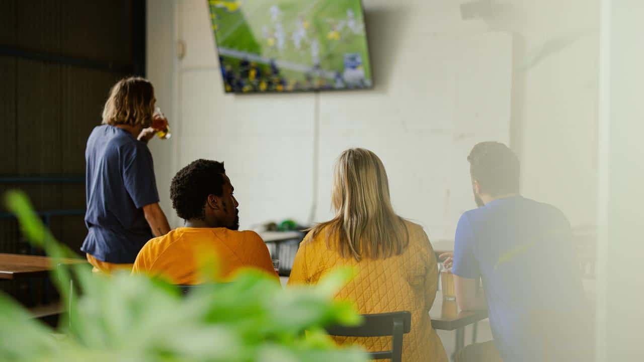 A group of people watching football on TV.