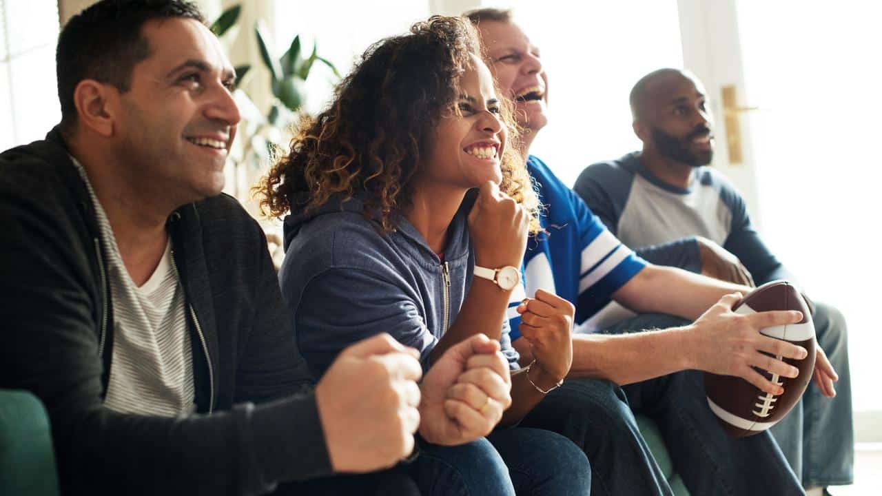 A group of friends excitedly watching football.