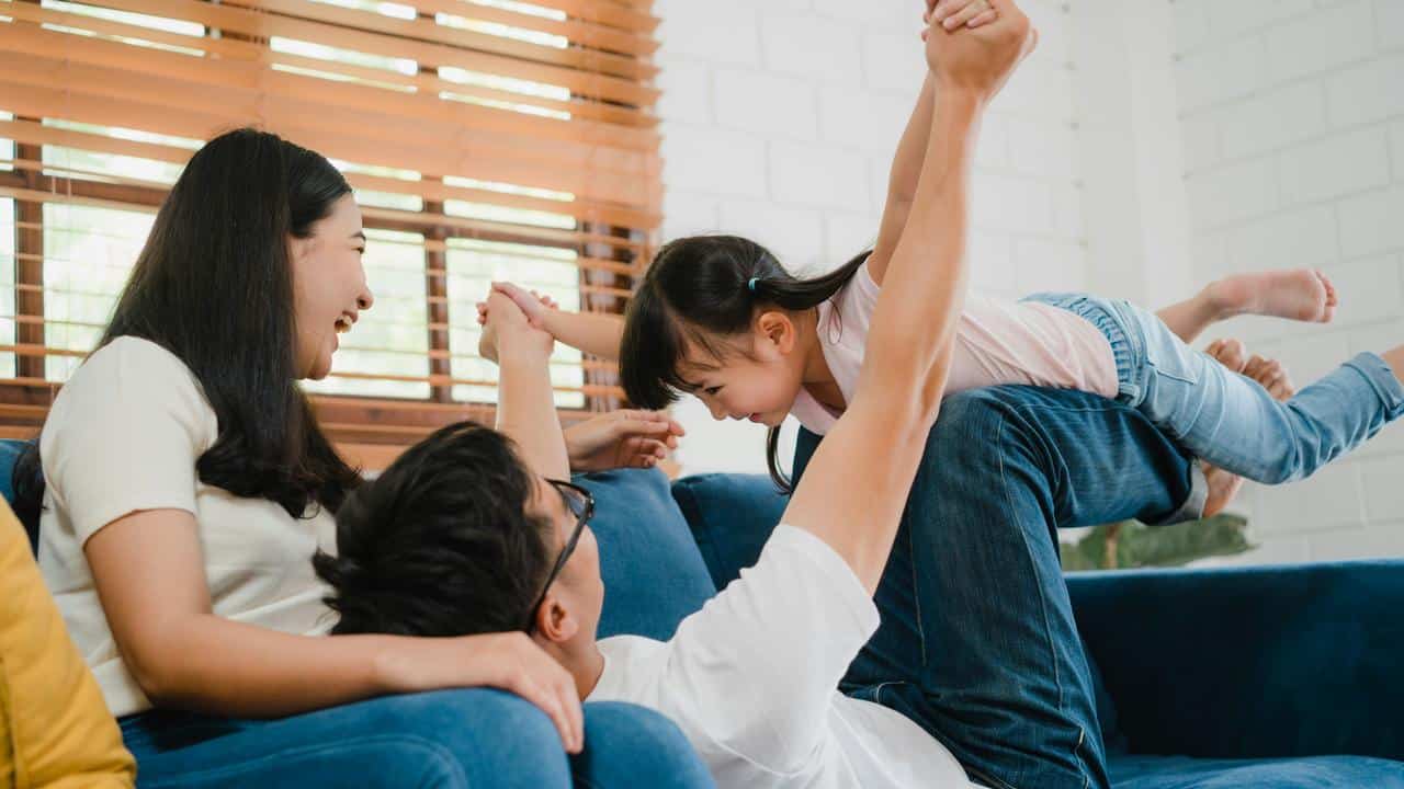 A family playing together on a couch.
