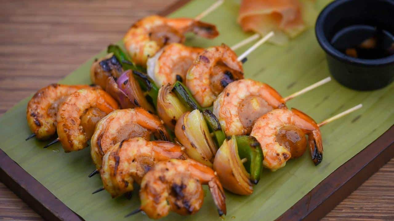 A plate of grilled shrimp skewers with vegetables.