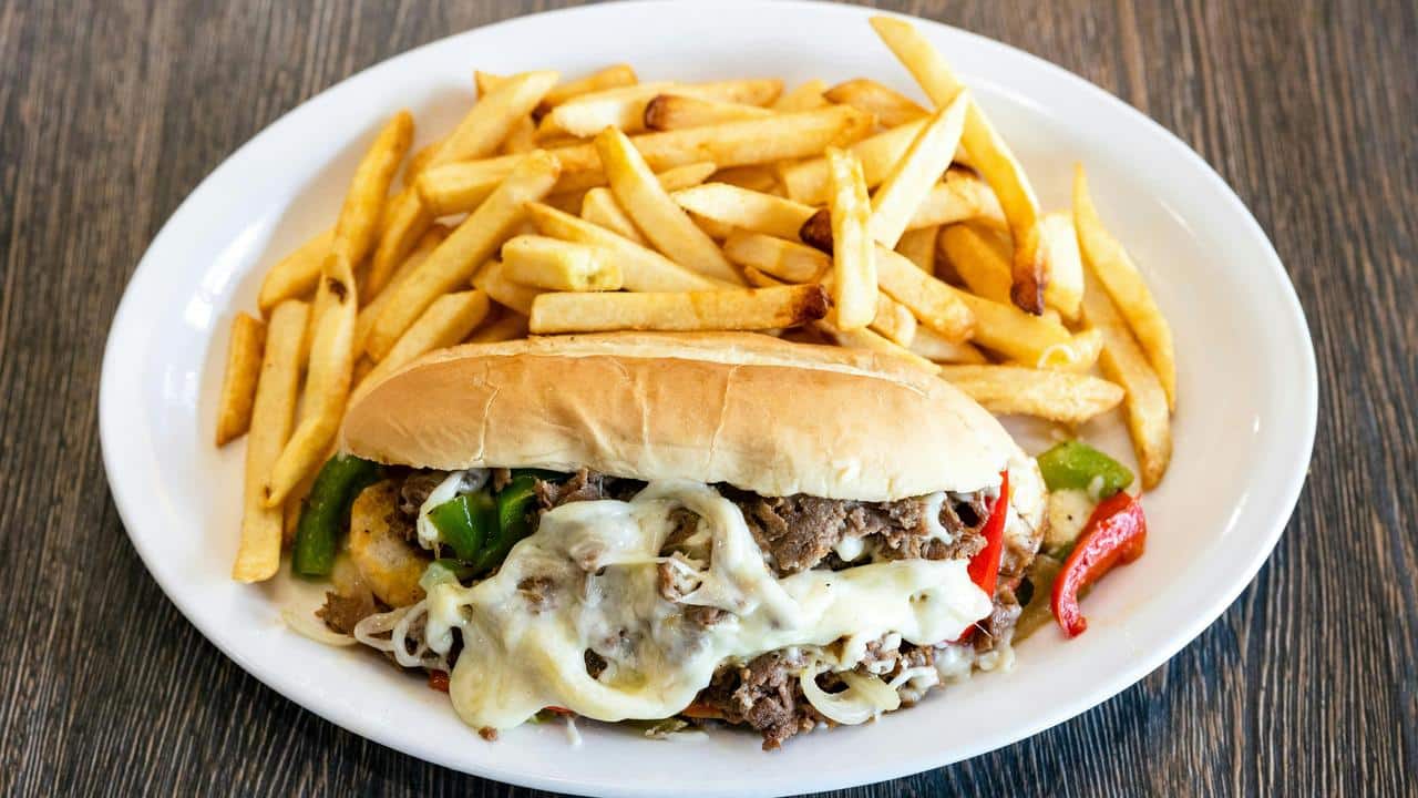 A cheesesteak sandwich with fries.