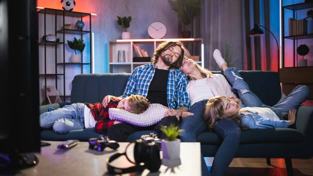 A family asleep together on a couch.