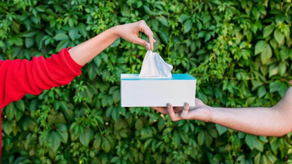 A person handing a tissue box to another person.