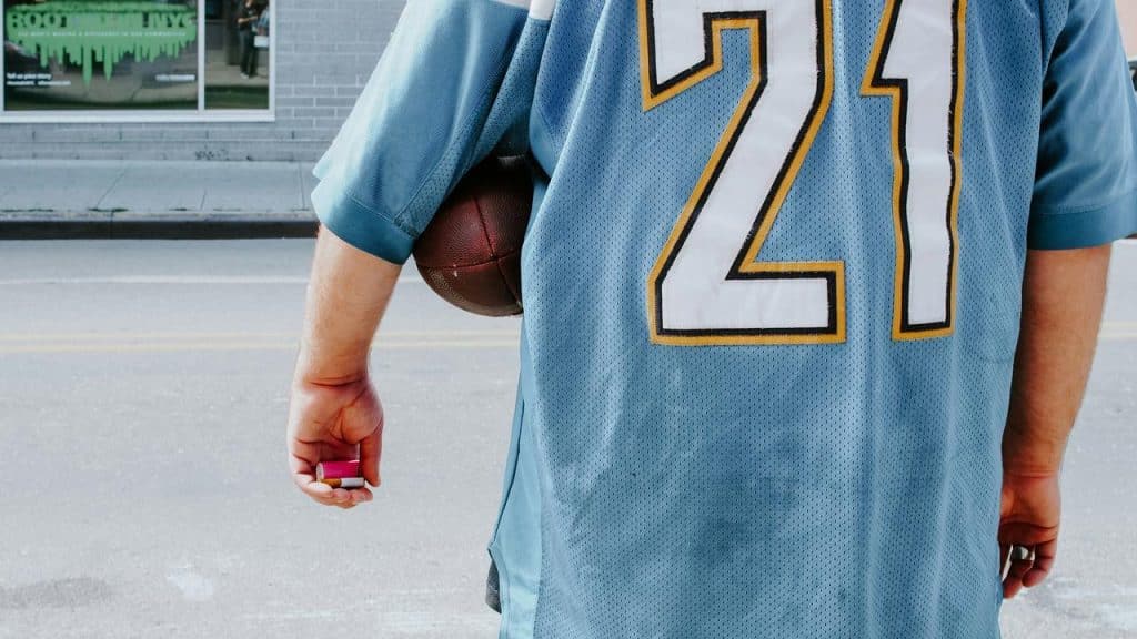 A person in a blue football jersey holding a ball.