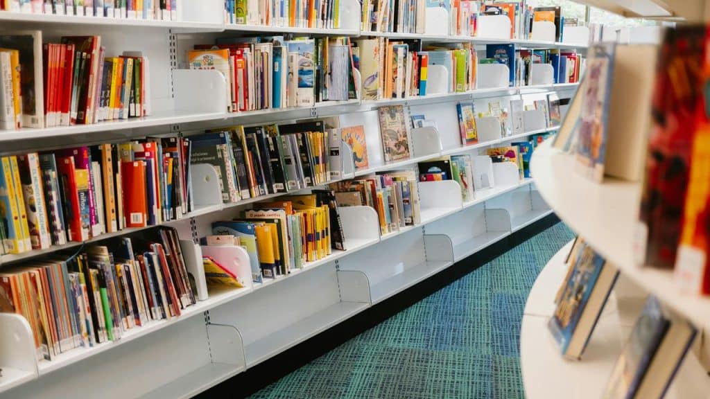 A library aisle filled with colorful books on shelves.