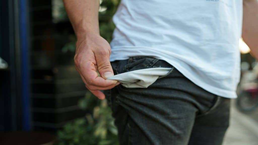 A man looking at his empty pocket.