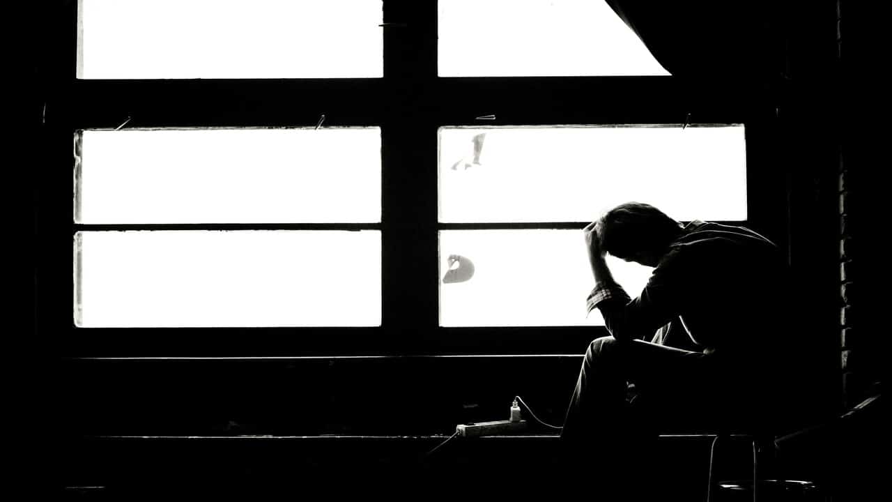 A sad man looking out the window.