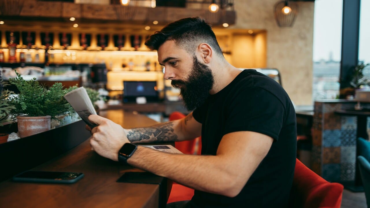 A man reading a newspaper in a cafe.