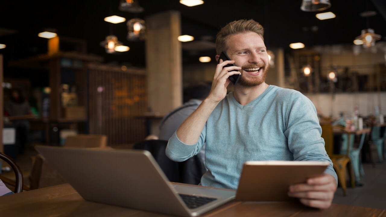 A man laughing while on the phone.
