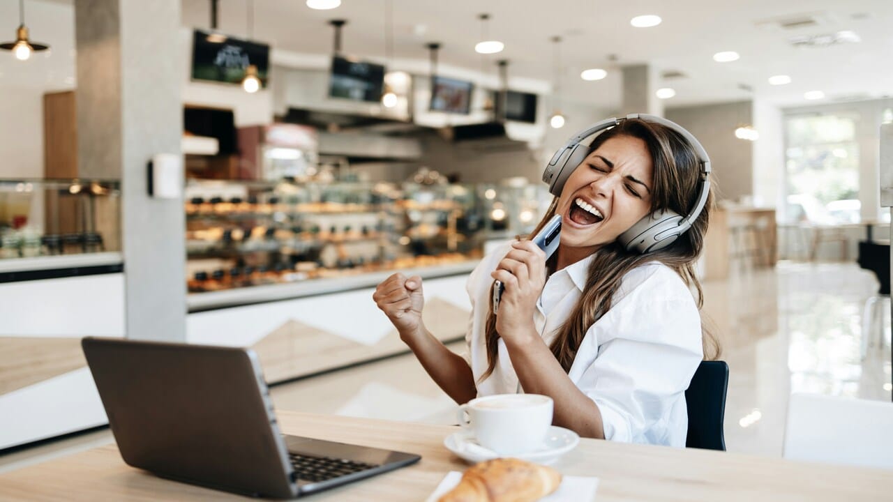 A woman happily doing karaoke by himself.