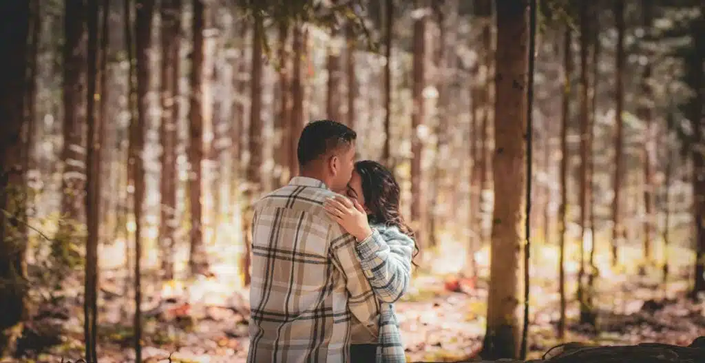 A man kissing a woman’s forehead