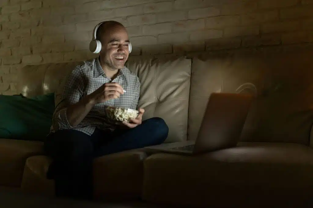 A man watching a movie with a popcorn