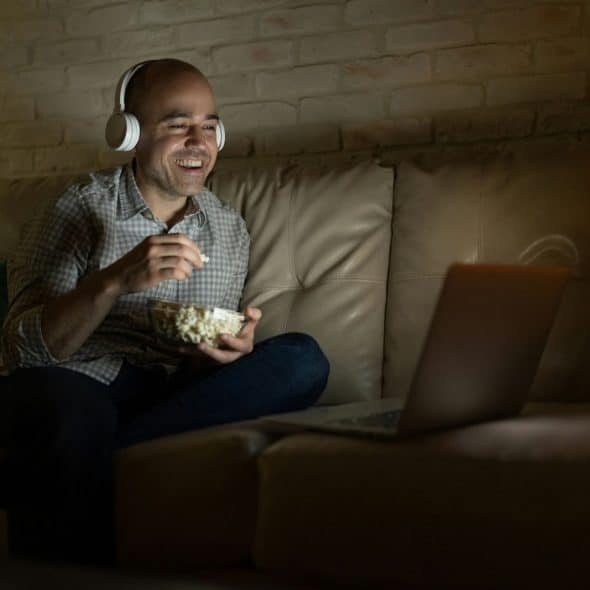 A man watching a movie with a popcorn