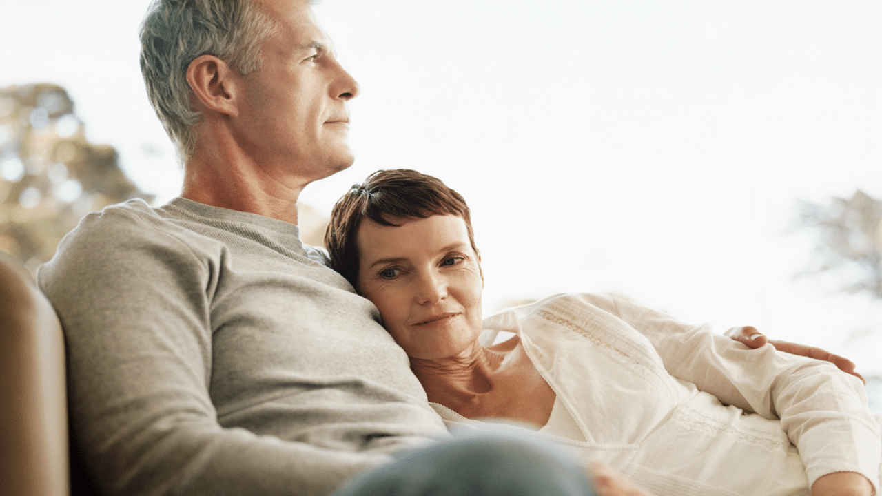 A mature couple sitting on the couch.
