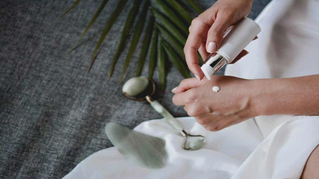 A woman pouring skincare on her hand.