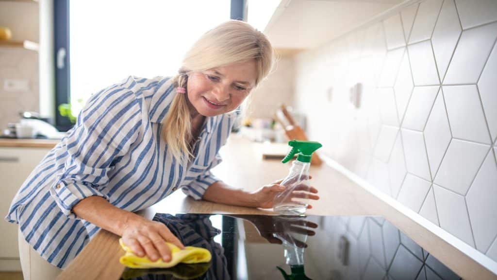 A woman wiping down her kitchen.