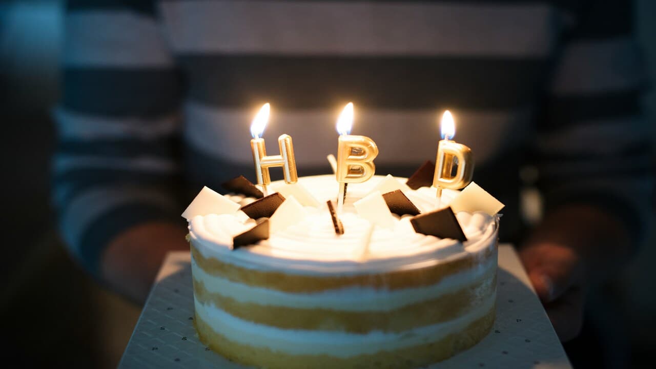 A person carrying a birthday cake.
