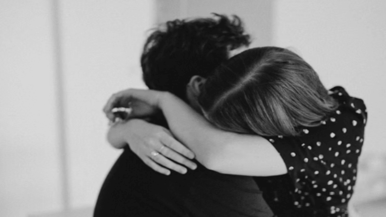 A couple hugging at home.