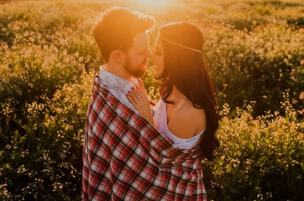 A man and woman kissing during sunset.
