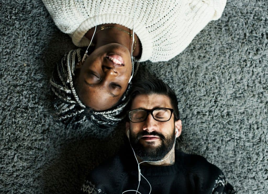 A man and woman listening to a music together.
