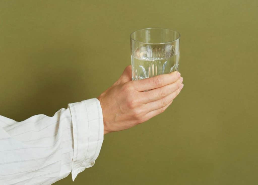 A person holding a glass of water.
