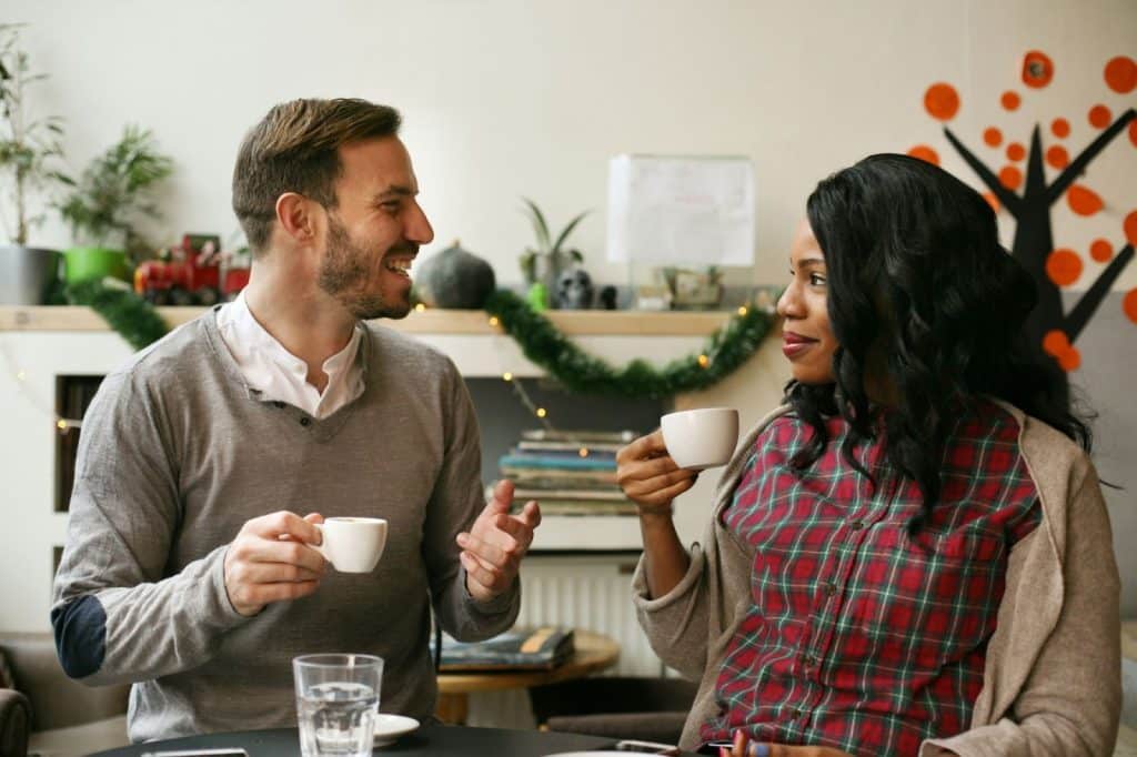 A man and woman talking and having a coffee.