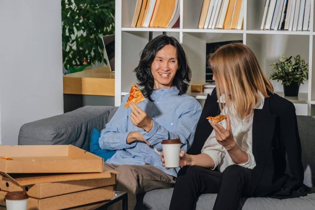 A man and woman eating a pizza while sharing to each other their dreams.