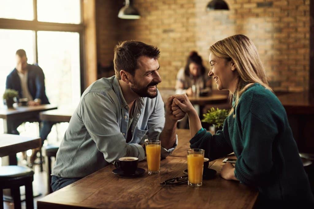 A man asking a woman while holding her hand.