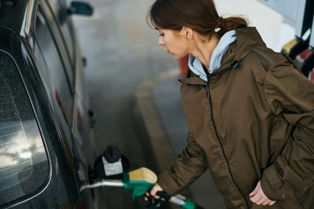 A woman filling a gas tank.