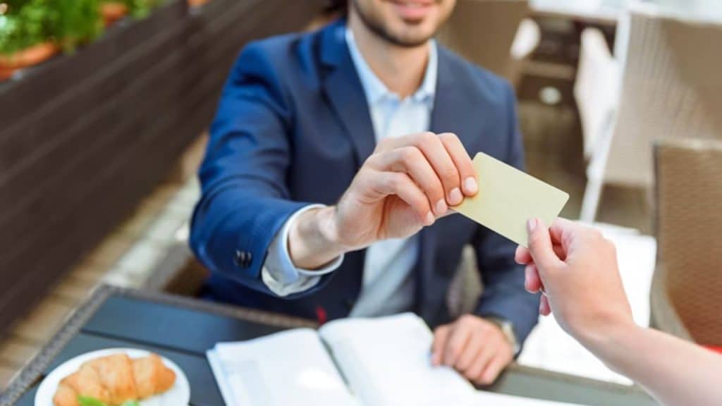 Man pulling out his card at the same time as the woman