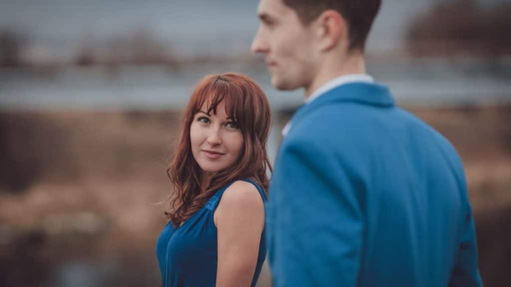 Woman expressing concern while man looks away.