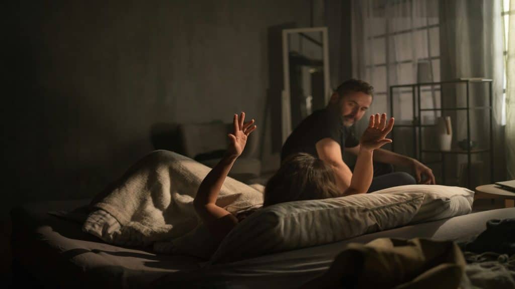 A couple arguing in bed.