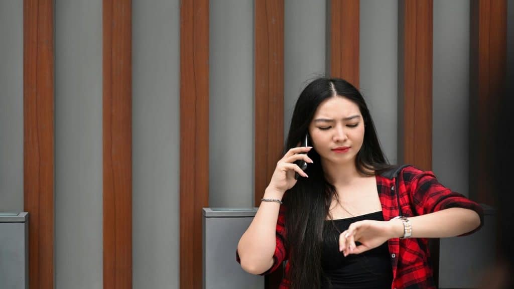 A Woman checking the time while on the phone.