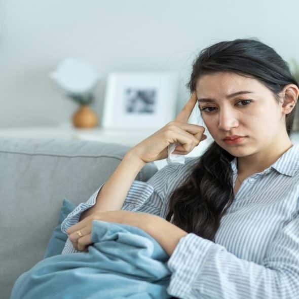 A woman looking sad at home.