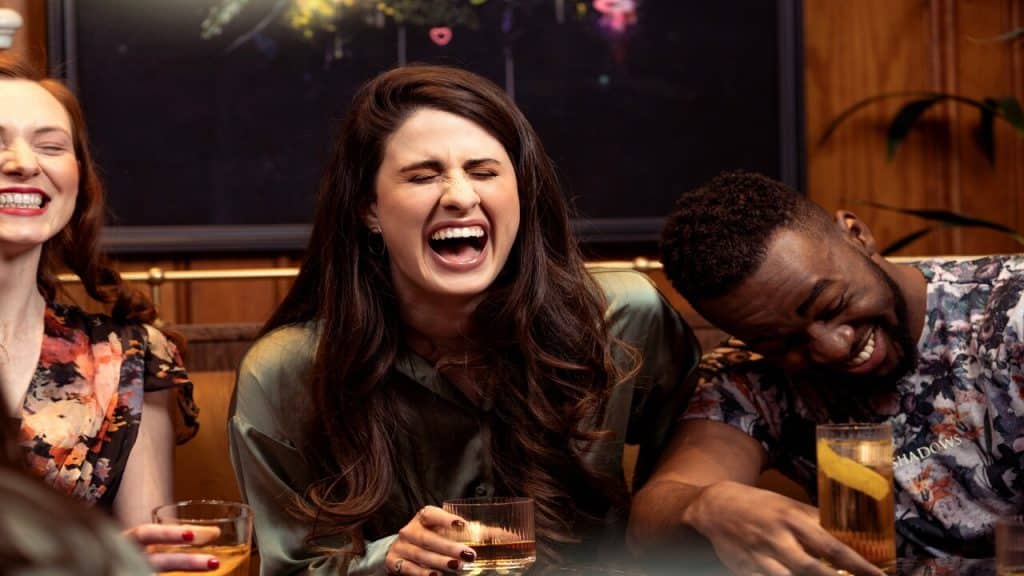 Friends laughing over drinks.
