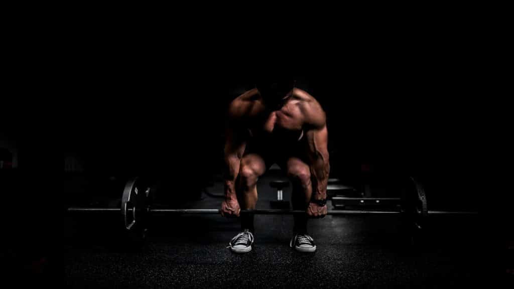 A man weight training in the dark,