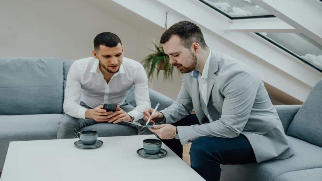 Two colleagues talking at a meeting.