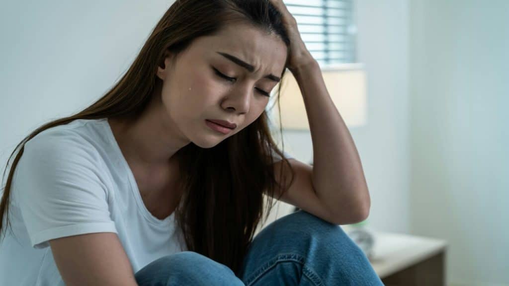 A woman looking sad at home.